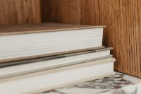 Kaboompics - Stacked White Book Pages Against Warm Walnut Wood Grain
