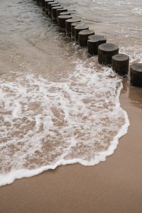Kaboompics - Foamy Wave Washing Over a Wooden Beach Groyne