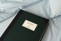 Kaboompics - Dark Green Planner on Soft Blue Bedding