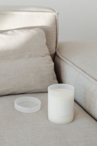 Kaboompics - Minimal Candle Jar and Lid in a Soft Neutral Sofa Setting
