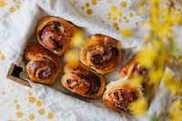 Kaboompics - Spring Cinnamon Roll Still Life on Yellow Speckled Table with Floral Bokeh