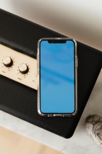 Kaboompics - Black speaker on marble table, white wall, mobile phone - mockup