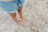 Kaboompics - Bare Feet Pressing into Pale Beach Sand, Woman in Denim Shorts on the Shore