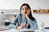 Kaboompics - Pensive Asian Woman Resting Her Head at an Office Desk