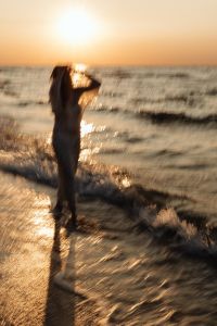 Kaboompics - Solitary Woman Walking by the Sea at Sunset