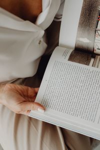 Kaboompics - Close-Up of Woman's Hand Holding an Open Book with Architectural Drawings