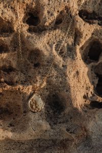 Kaboompics - Delicate Gold Pendant Necklace on Porous Malta Limestone