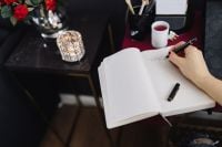 Kaboompics - Writing in an Open Notebook with Tea at a Pink Home Office Desk