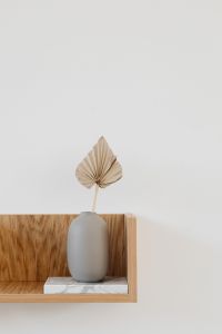 Kaboompics - Dried Palm Leaf in White Ceramic Vase on Minimal Wood Shelf