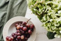 Kaboompics - White Hydrangea Vase and Red Grapes on a Neutral Table
