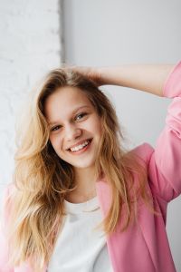 Kaboompics - Warm Smiling Blonde Portrait in a Pink Blazer with Airy White Copy Space