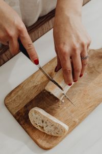 Kaboompics - Overhead Bread Slicing on a Wooden Cutting Board
