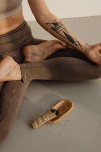 Kaboompics - Close-Up of Crossed Legs and Smoldering Sage on a Yoga Mat