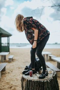 Kaboompics - Woman Bending Forward on Sandy Beach by Picnic Benches
