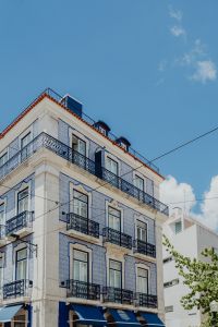 Kaboompics - White Azulejo-Covered Corner Building with Iron Balconies and Tram Wires