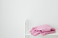 Kaboompics - Folded Pink Sweater on a White Shelf