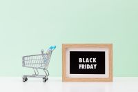 Kaboompics - Black Friday Sign beside Empty Shopping Cart on Mint Green Background