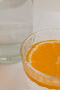 Kaboompics - Macro Detail of an Orange Slice in a Textured Water Glass, Fresh Citrus Drink Background