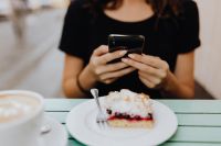 Kaboompics - The girl is using the phone in the cafeteria