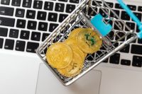 Kaboompics - Mini Shopping Cart With Bitcoin Coins on Laptop