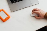 Kaboompics - Man works on a computer at his desk, mobile phone, portable hard drive