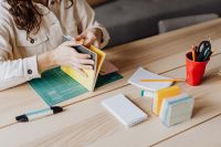 Kaboompics - Woman Reviewing Open Book at Desk with Notebook