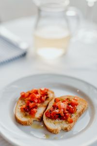 Kaboompics - Blurred Wine Glass and Tomato Bruschetta Table Scene