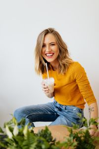 Kaboompics - Laughing Woman Leaning Forward with a Milkshake