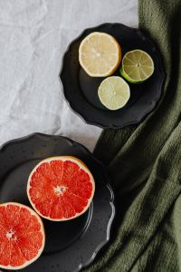Kaboompics - Vertical Grapefruit and Citrus Flat Lay on Dark Plates with Green Linen, Recipe Content