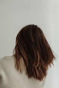 Kaboompics - Woman Turning with Tousled Brown Hair and Beige Knitwear