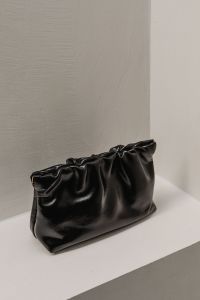 Kaboompics - Black Ruched Leather Handbag on White Shelf