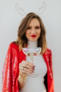 Kaboompics - Soft-Focus Champagne Toast with Woman in Red Holiday Suit