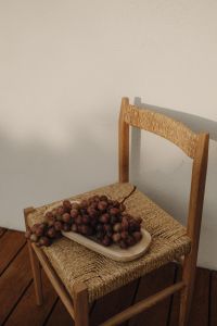Kaboompics - Red Grapes on Woven Chair with Neutral Wall