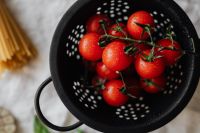 Kaboompics - Fresh Cherry Tomatoes in Black Colander with Spaghetti Nearby