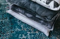 Kaboompics - Stack of pillow of a light blue carpet
