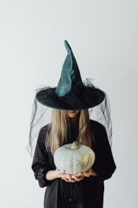 Kaboompics - Woman in Witch Costume with Gray Pumpkin Portrait