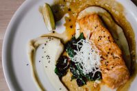 Kaboompics - Close Detail of Salmon Fillet, Cream Sauce and Wilted Spinach on White Plate