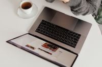 Kaboompics - A brunette woman works with a laptop and a phone
