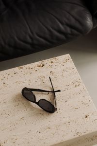 Kaboompics - Black Sunglasses on Travertine Table Beside Black Leather Sofa