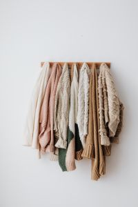 Kaboompics - Neutral Sweaters Hanging on Minimal Wall Rack