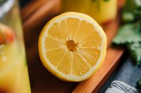 Kaboompics - Fresh Lemon Slice with Summer Drink in the Background, Bright Ingredient Still Life