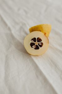 Kaboompics - Japanese Quince Half Macro with Dark Seeds and Golden Peel on Rumpled White Linen