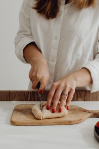 Kaboompics - Close-Up of Hands Slicing Rustic Bread