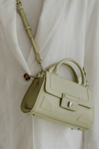 Kaboompics - Sage Green Structured Handbag with Long Strap on White Suit