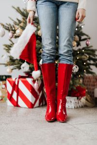 Kaboompics - Woman Wearing Red Boots and Holding a Santa Hat by Tree