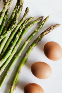 Kaboompics - Vertical Close-Up of Asparagus Spears and Brown Eggs on White Background
