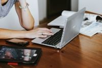 Kaboompics - Woman Working on a Silver Laptop with a Tablet at Her Desk