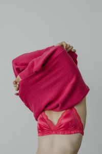 Kaboompics - Woman Pulling a Fuchsia Sweater over Her Head