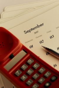 Kaboompics - September 2027 Calendar With Red Retro Telephone and Pen