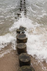 Kaboompics - Crashing Waves Around Wooden Groyne Posts